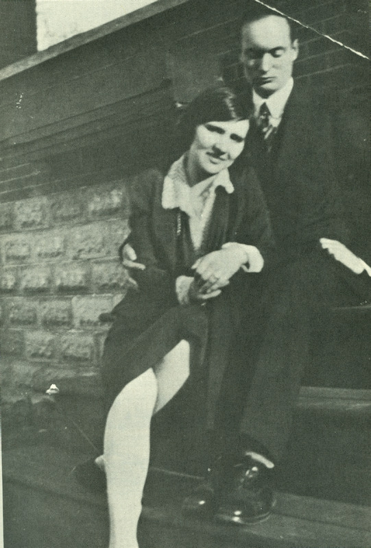 Raymond and Myrtle Knister sitting on a staircase. Raymond has his hand around Myrtle and is looking down. Myrtle is sitting on a lower step and is leaning on Raymond's leg and smiling at the camera. 