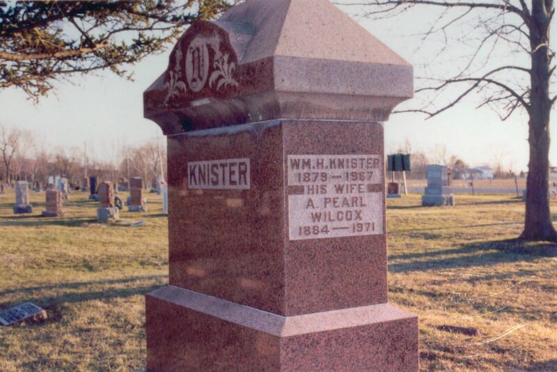 Side on view of a large pink rectangular marble gravestone with the name Knister on front and the names of the specific deceased carved on the side. 
